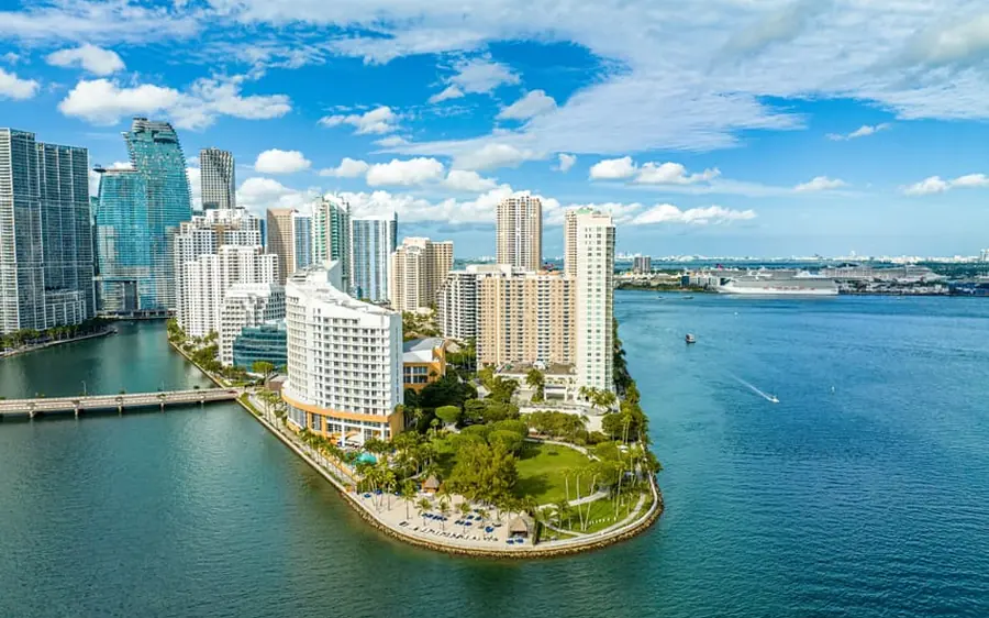 A private helicopter climbing over Biscayne Bay near Coconut Grove